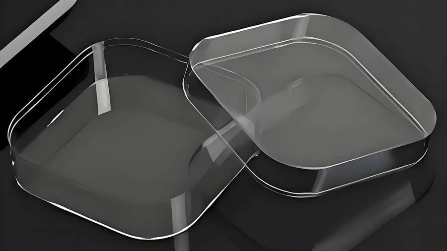 Two clear, square-shaped containers with rounded edges on a dark surface.