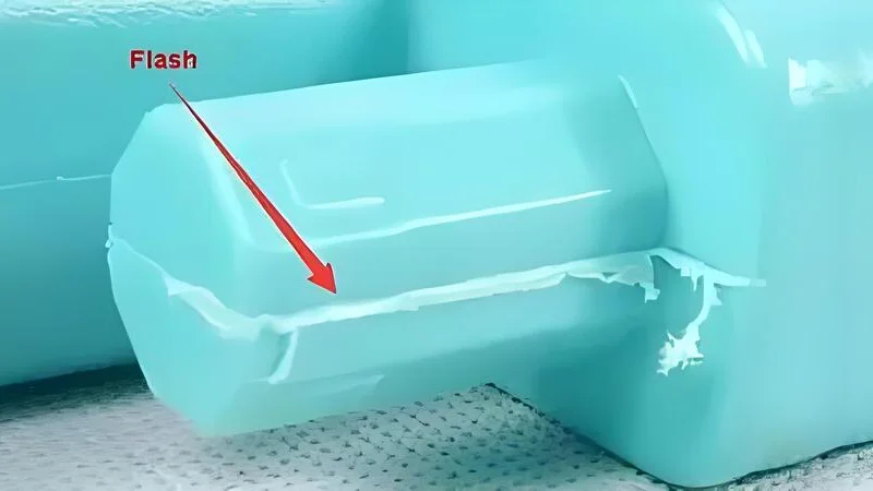 Close-up of injection molded plastic components showing flash defects