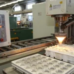 Injection molding machine producing button molds in a factory