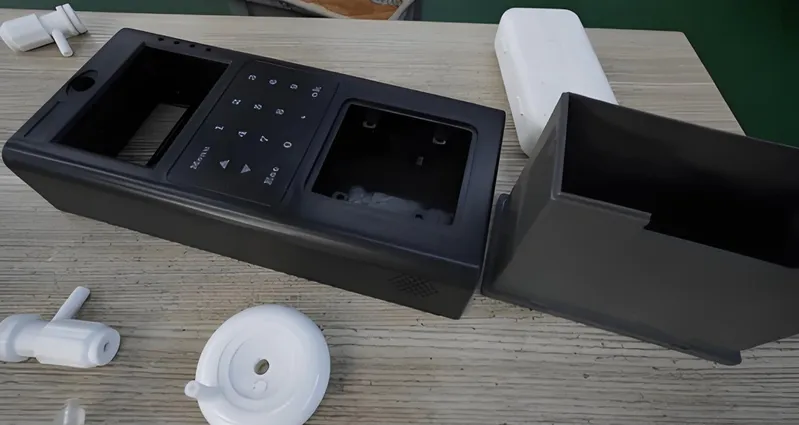 Disassembled electronic device housing on a table with various components around.
