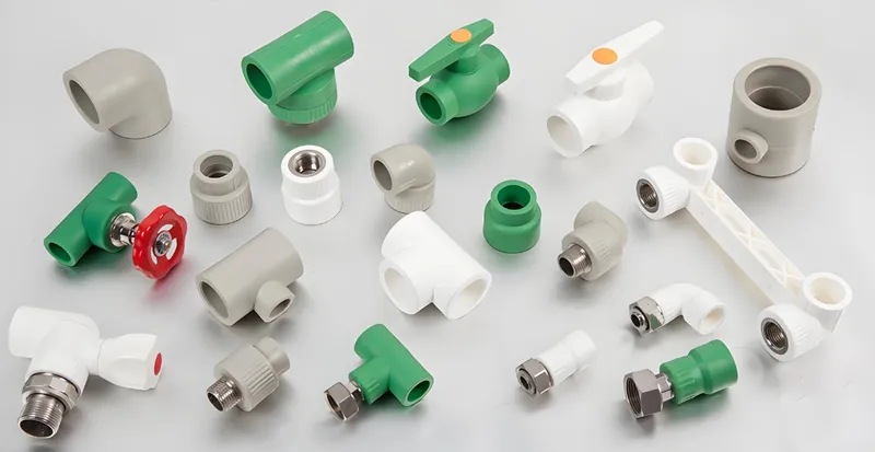 A variety of piping fittings in different shapes and sizes, including connectors, valves, and elbows, in colors green, white, and gray.