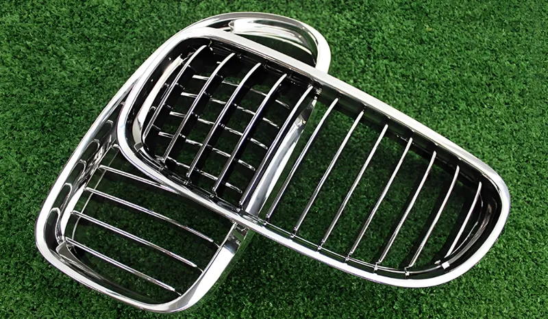Two chrome car front grills placed on green grass