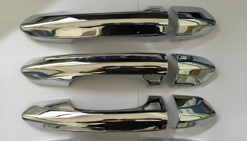 Shiny chrome car door handle covers displayed on a white surface