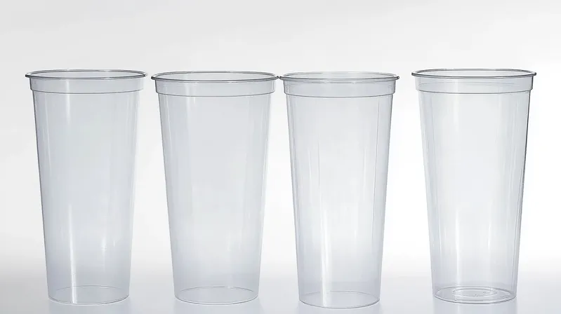 Four transparent plastic cups arranged in a row against a light background