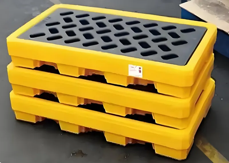 Stack of yellow industrial spill pallets