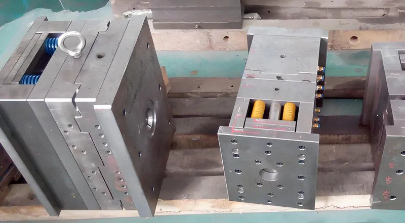 Metal mold bases on a wooden pallet in a workshop