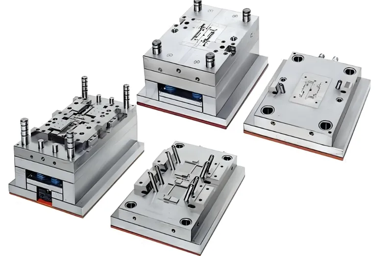 Four injection molds displayed on a surface