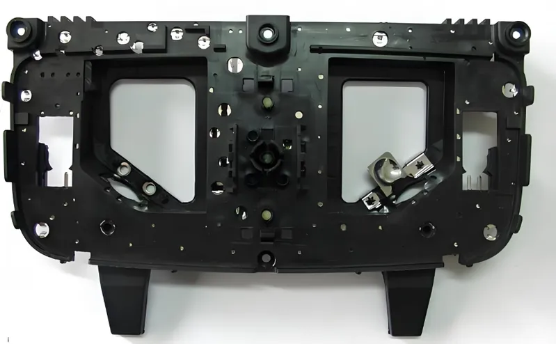 Front view of a black plastic instrument panel frame with multiple mounting points and cutouts for gauges
