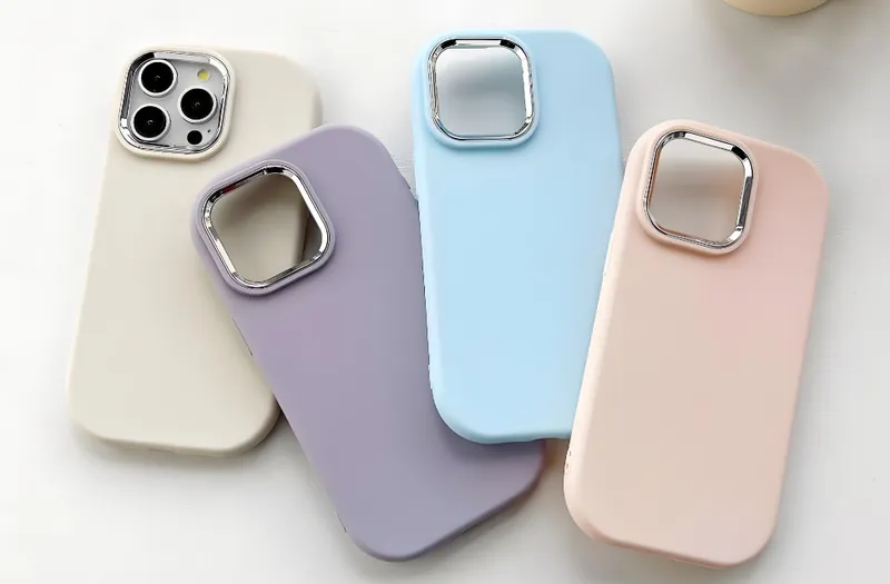 Four smartphone cases in different colors - white, purple, blue, and pink - displayed on a surface
