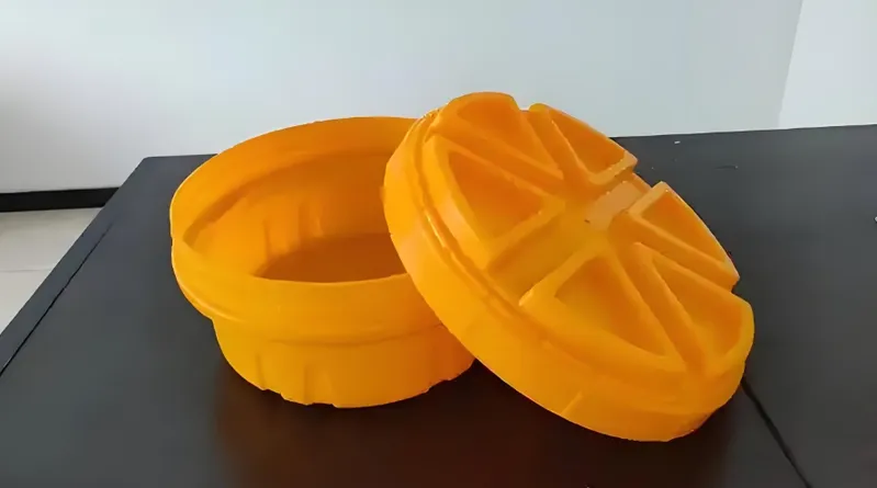 An orange plastic container with a lid shaped like an orange fruit