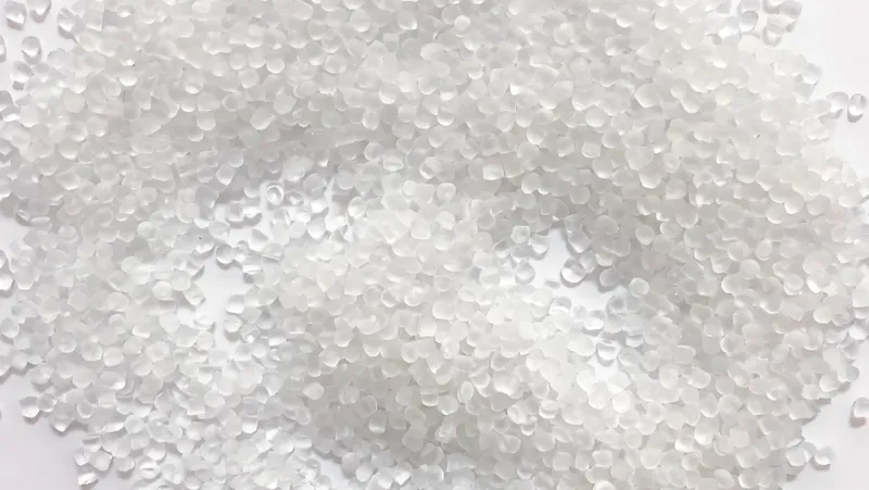 A close-up of white polyethylene plastic pellets scattered on a surface