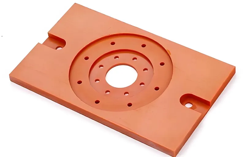 An orange router base plate with multiple holes arranged in concentric circles
