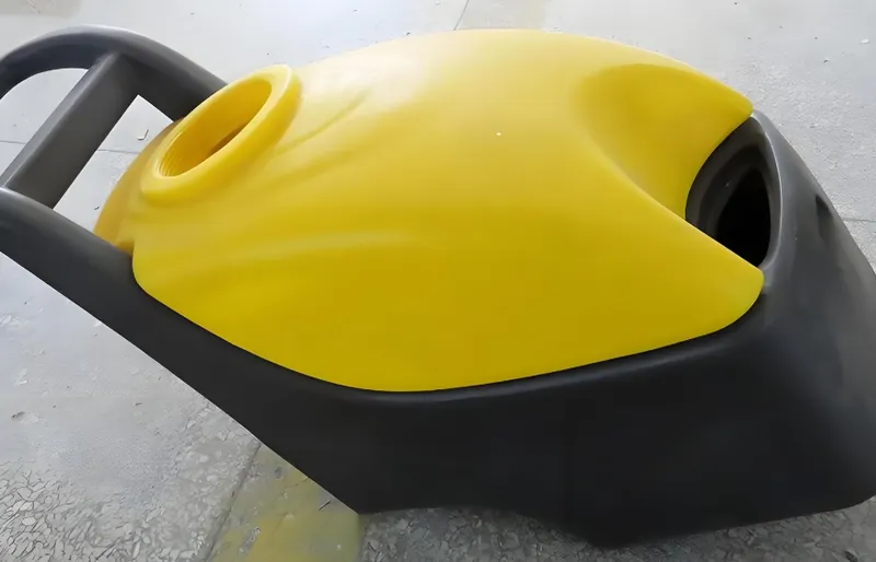 Yellow and black plastic shell of a vacuum cleaner placed on a gray textured floor
