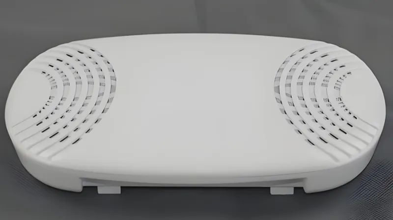A flat, oval-shaped white plastic object with curved vents on each side