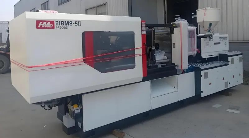 A large injection molding machine outside a building