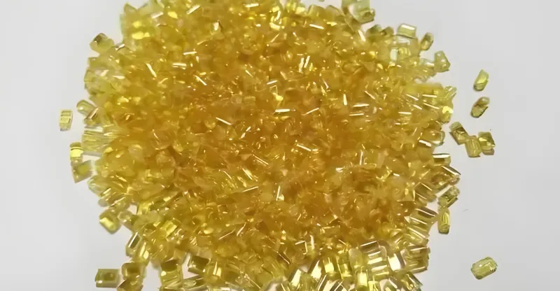 A pile of yellow plastic pellets on a white background