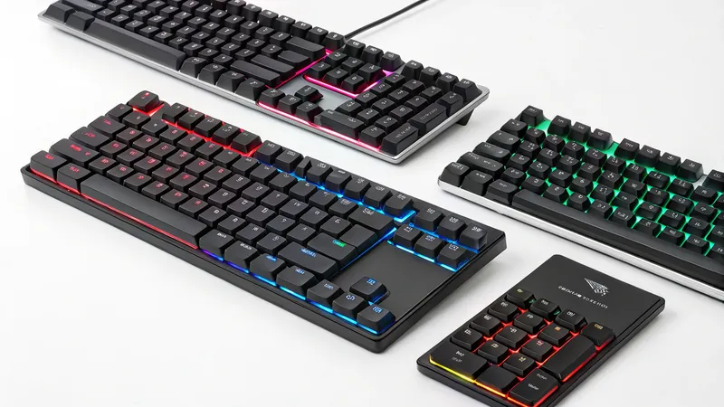 A collection of RGB-lit mechanical keyboards and a keypad on a white surface