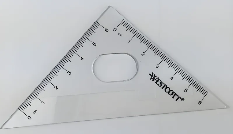 A clear Westcott triangle ruler with centimeter markings and a central oval grip