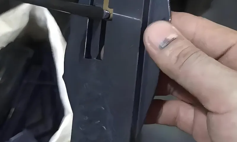 Hand holding and inserting a small battery into a device