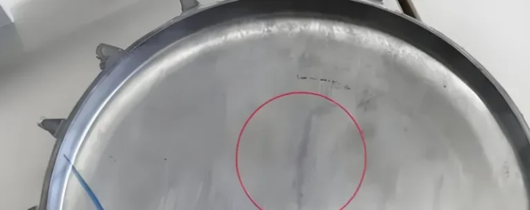 কেন্দ্রে টানা একটি লাল বৃত্তযুক্ত একটি বড় ধাতব id াকনা।