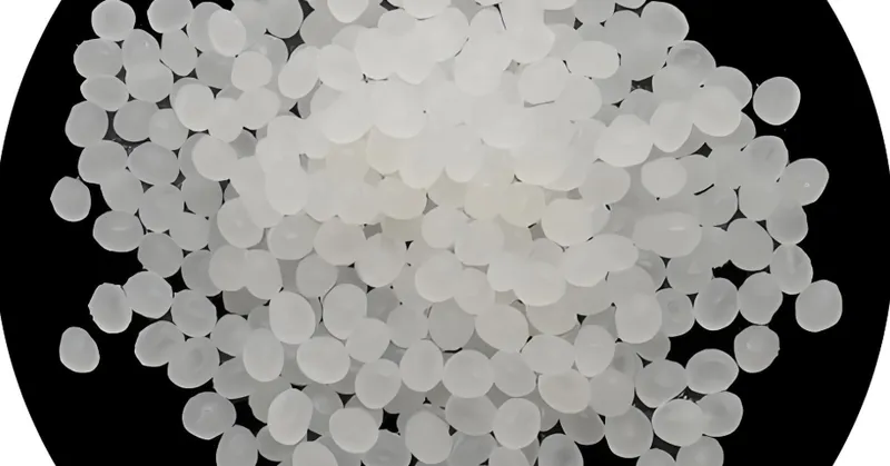 Close-up view of white plastic pellets on a black background