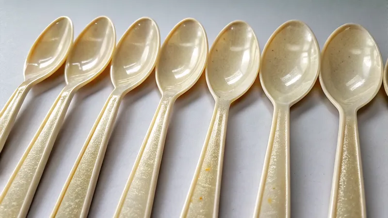 A close-up view of eight wooden spoons arranged in a row on a flat surface