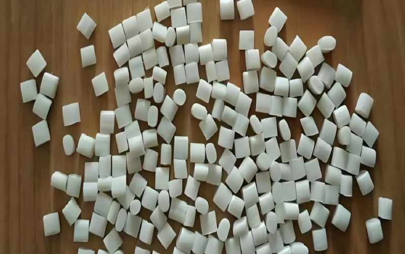 A wooden surface covered with scattered small white marshmallows