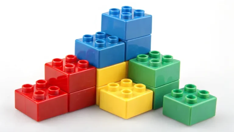 Uma pilha de blocos de construção plásticos coloridos em vermelho, azul, amarelo e verde.