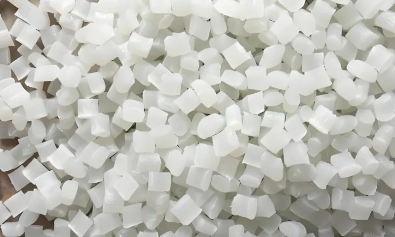 A close-up image of small white plastic pellets piled together